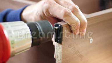 木工师傅用螺丝刀拧螺丝.. 男人收集家具。 男人`工作和爱好。